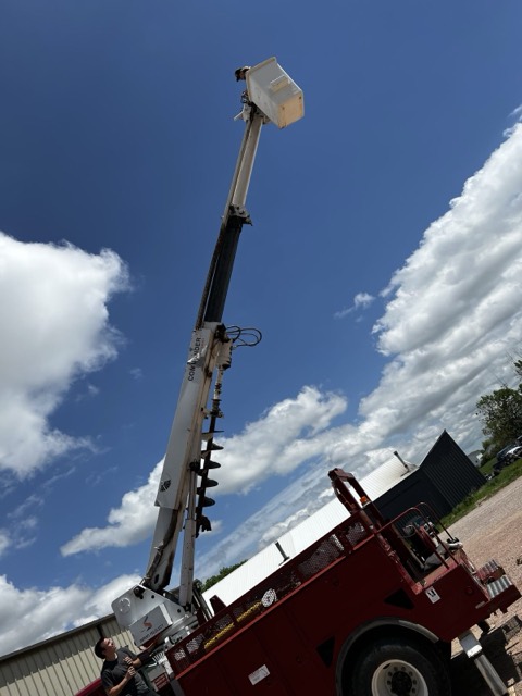 Boom truck with auger on a job site