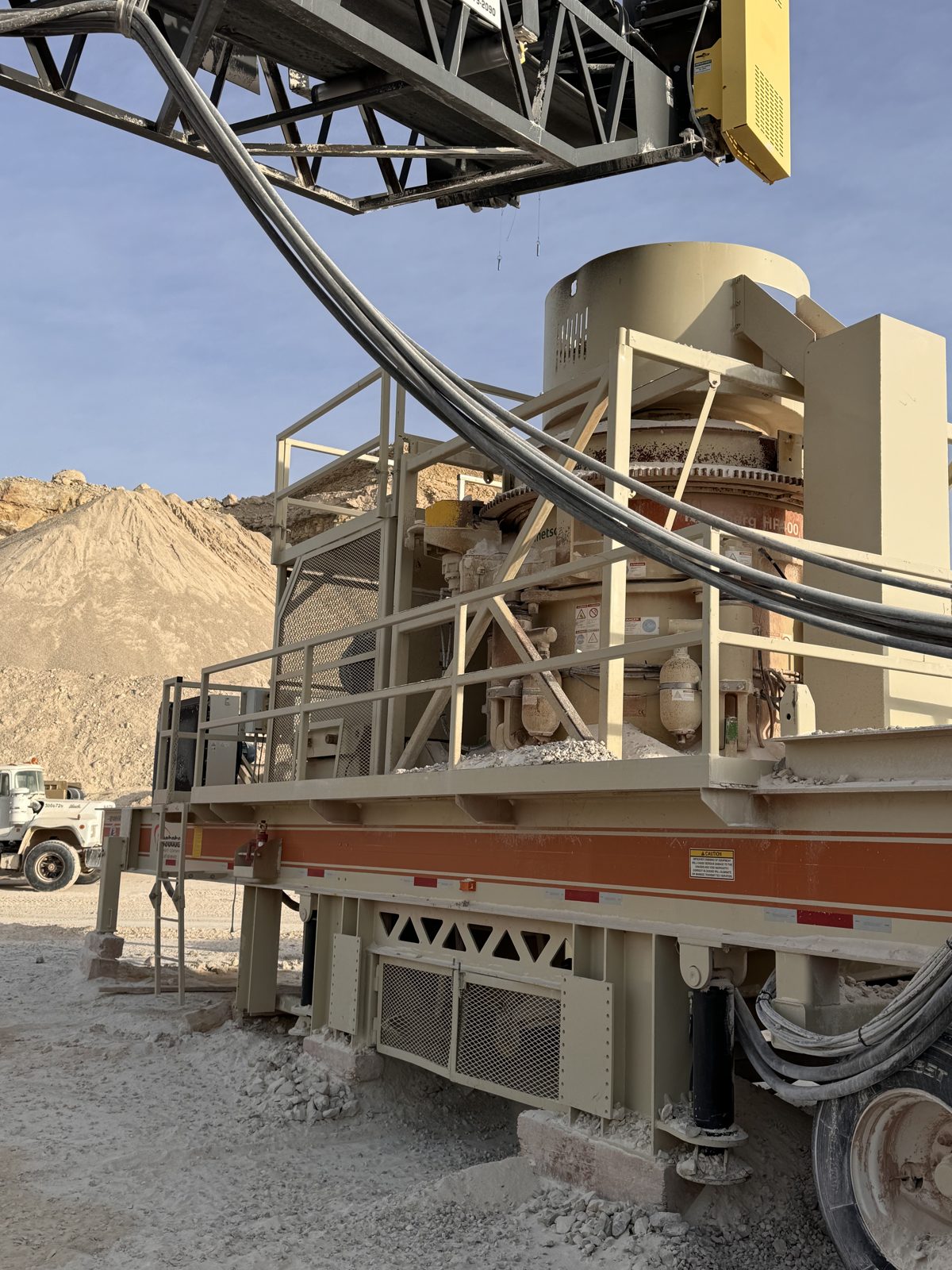 Portable cone crusher wired and running at a quarry site