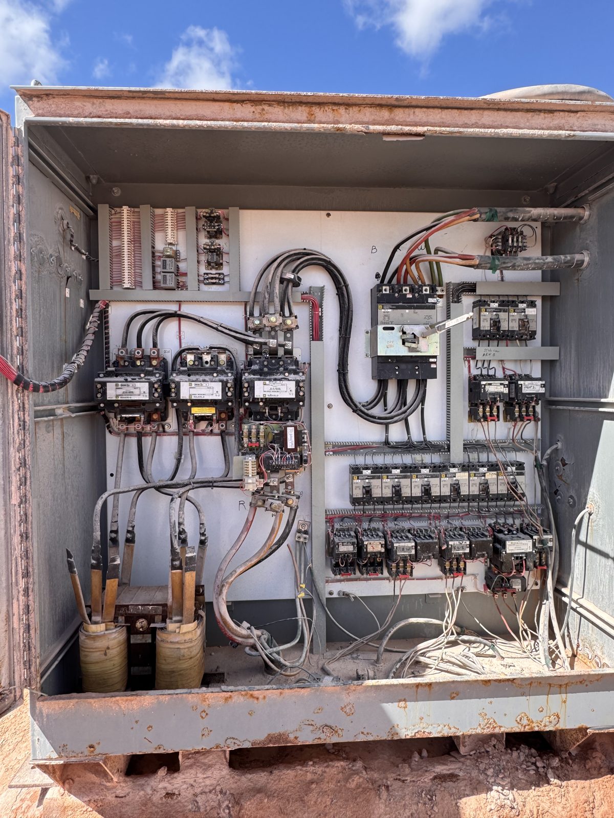 Weathered outdoor industrial control cabinet opened for repair